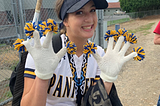 Woman at softball game with white gloves.