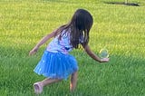 Young girl with hand reaching out, palm facing up. A large bubble is right above her palm.