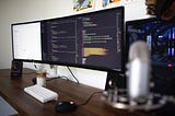 The workplace of a web developer, big monitors with code on a table