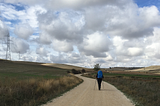 a Camino walker — me — walking Camino under a very big sky in Spain