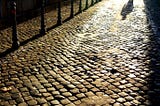 Man walking on cobblestone street