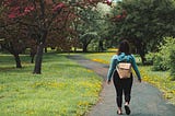 woman with backpack walking on a trail