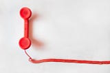 a corded red telephone