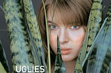 A young white girl stares at the camera from among the large leaves of a plant. “Uglies” is written in white font.