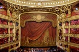 View of gilded, red-curtained stage.