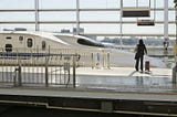 A woman in Kyoto gets ready to board a bullet train heading for Tokyo, Japan