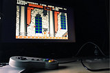 Al fondo, Castlevania en la pantalla y en primer plano un mando de Super NES