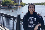 A female smiling to the camera. Behind her is a river.