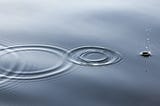 The image of three ripples on a still lake forming concentric circles