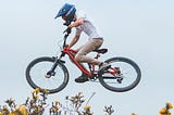 Young boy flying through the air on his bicycle.