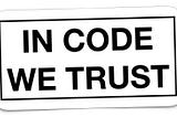 IMAGE: A white sticker with the words “In code we trust”