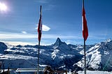 The Matterhorn in between a Valais canton flag and a Swiss flag