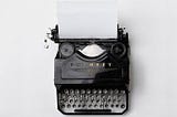 Antique typewriter with a blank page awaiting your genius