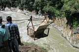 Disaster Response Team members and volunteers transporting relief materials (tents, black boards, stationery items) for a school damaged by a flood.