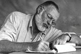 Ernest Hemingway writing by hand while on safari.