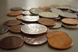 Close-up of a  pile of coins scattered on a flat surface