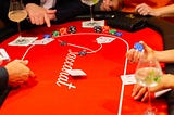 players around a baccarat table laying down their bets