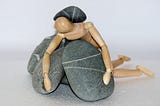Wooden figure with rocks piled around