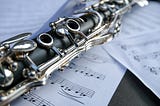 Close up of a clarinet resting on pages of sheet music
