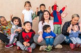 Child care provider Miren Algorri surrounded by children and her co-workers.