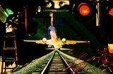 a collage created by author. Train tracks, a plane taking off, eyes in a rearview mirror.