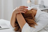 burnt out teacher with head buried in desk.