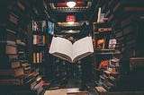 A floating book surrounded by a circle of books, looking like a stone portal, stacked on and against one another.