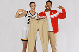 Picture of Caitlin Clark and Jake from State Farm smiling together and holding up a pair of sweat-pants.