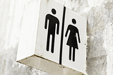A sign indicating public men’s and women’s washrooms.