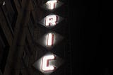 A lit up hotel sign on East Hastings, an infamous street where homeless people reside together