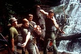 In a scene from the film Deliverance, Burt Reynolds aims his bow downriver as Ned Beatty, Jon Voight and