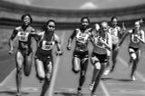 Black and white photo of female sprinters.