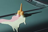 Ice cream upside down, melting on an engine hood.