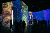 Vincent van Gogh exhibit with silhouettes of people onserving