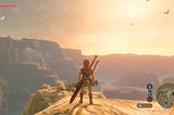 A screenshot from The Legend of Zelda: Breath of the Wild. Link is stood on a cliff edge as the sun sets. He is gazing across the scenery.