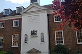 A white central portion in a red-brick building with features.