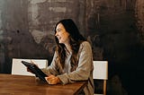 Woman with laptop smiling.