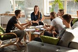 A group of men and women gathered around a table working