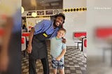 Man poses with boy smiling.