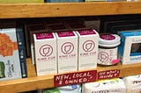 Kind Cup, a reusable menstrual cup, is shown on the shelf of a natural foods store among other products.