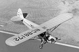 The pilot is trying to start the stalled propeller of his plane in flight