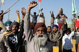 Protesting farmers shout slogans as they clash with police while attempting to move toward Delhi