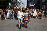 Group of people marching with various rainbow and Trans pride flags. In front: General Secretary from Salam, an organisation serving queer Muslims. Begard Reza (left) marches beside the leader of Steatornis, Maria Puenchir. Credit: Shahram Kiani.