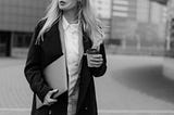 Business woman with long hair, a computer and coffee looking to the right. Image courtesy of Tima Miroshnichenko at Pexels.