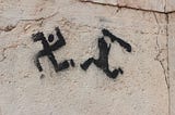 A graffiti that depicts a black and white shadow person persuing a caricatured swastika with a club