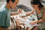 diverse-couple-having-breakfast-in-cafe-while-exploring-map