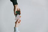 A person holding a credit card over to tap a card reader and pay for a purchase