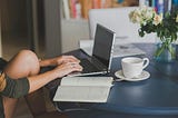 Women sitting at a table using her laptop