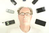 Self portrait of my head surrounded by all the cell phones that I’ve owned