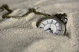 Pocket watch buried in the sand